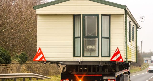 Static caravan being transported after being sold